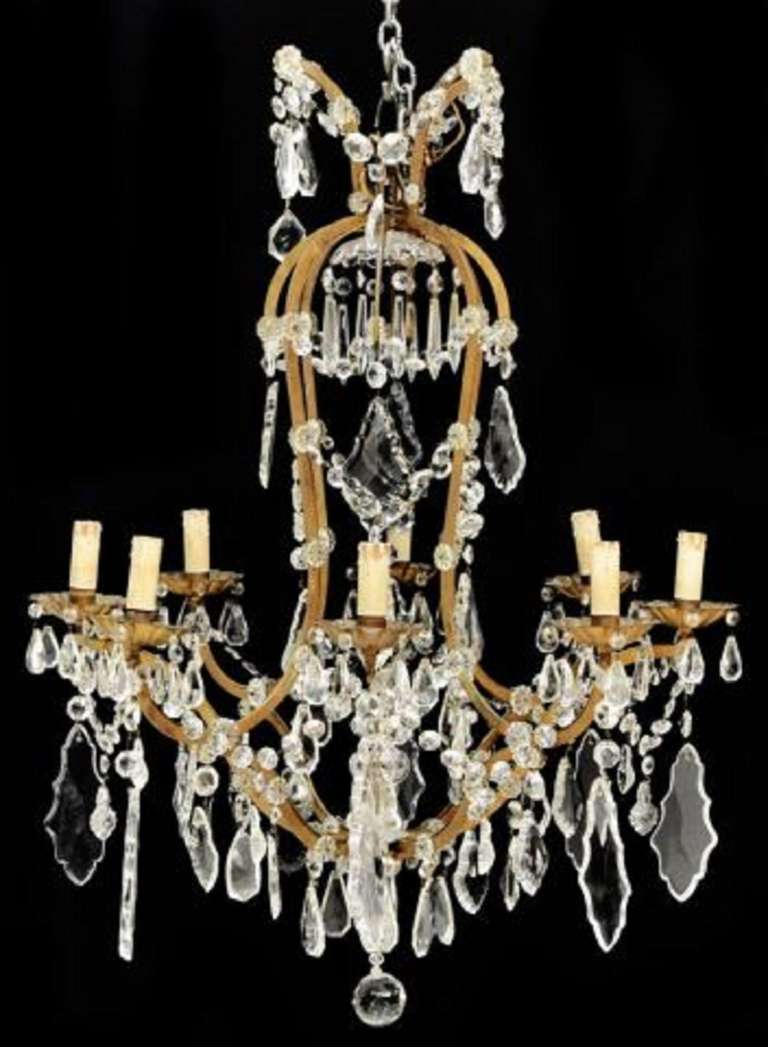 Early 20th Century Italian Gilt Metal and Crystal Eight Light Chandelier, hung with colorless prisms and swags, flower head detail, and faceted ball drop