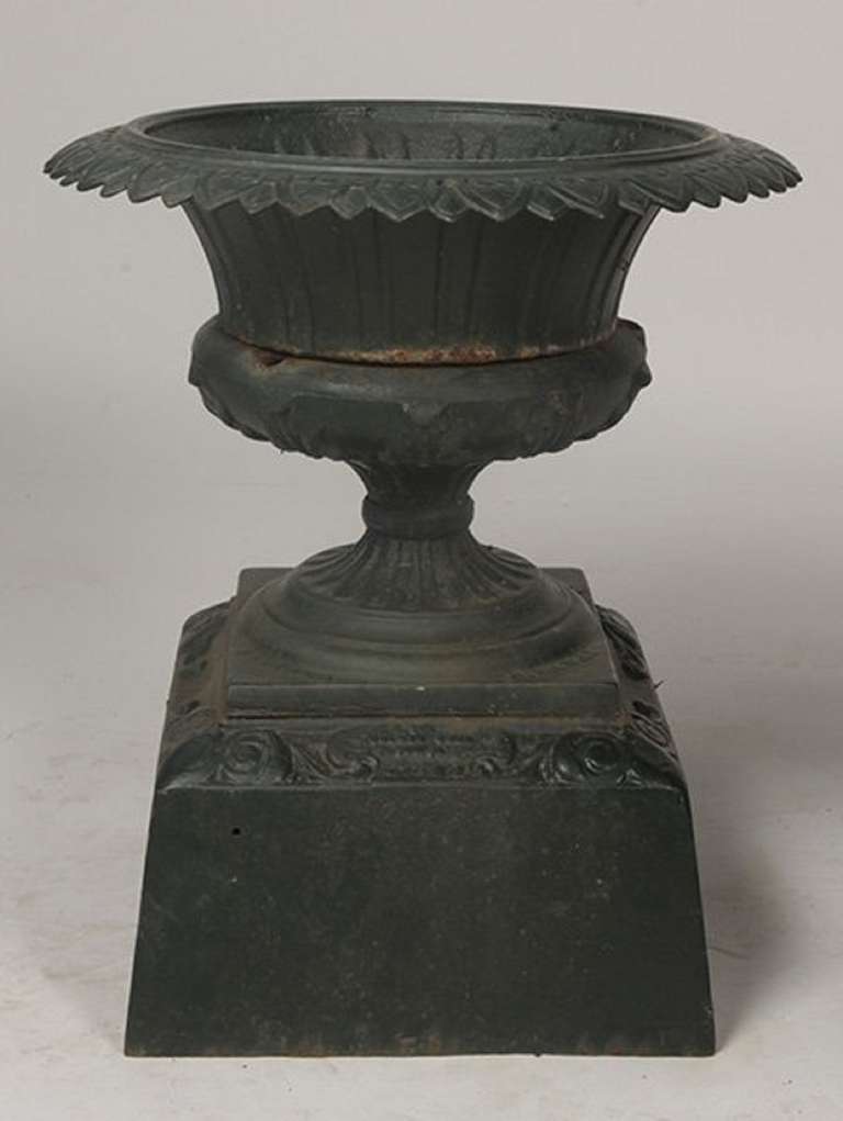 Late 19th Century Pair of American labeled Kramer Brothers Cast Iron Urns with shaped rims and fluted bowls raised on a plinth base