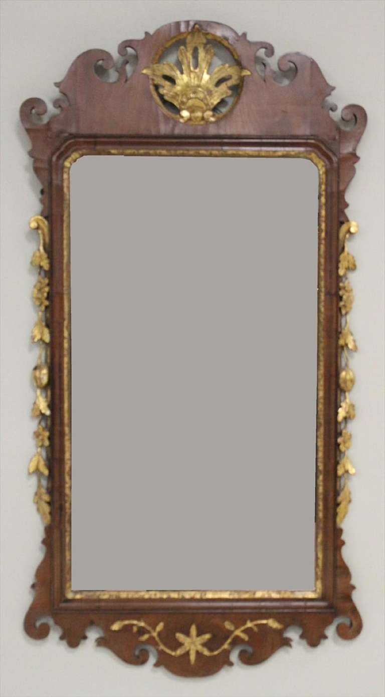 Late 18th Century Queen Anne Gilt Walnut Wall Mirror, English, surmounted by pierced gilt circular leaf over rectangular mirror with gilt interior molding and flanked by gilt fruit and flowers