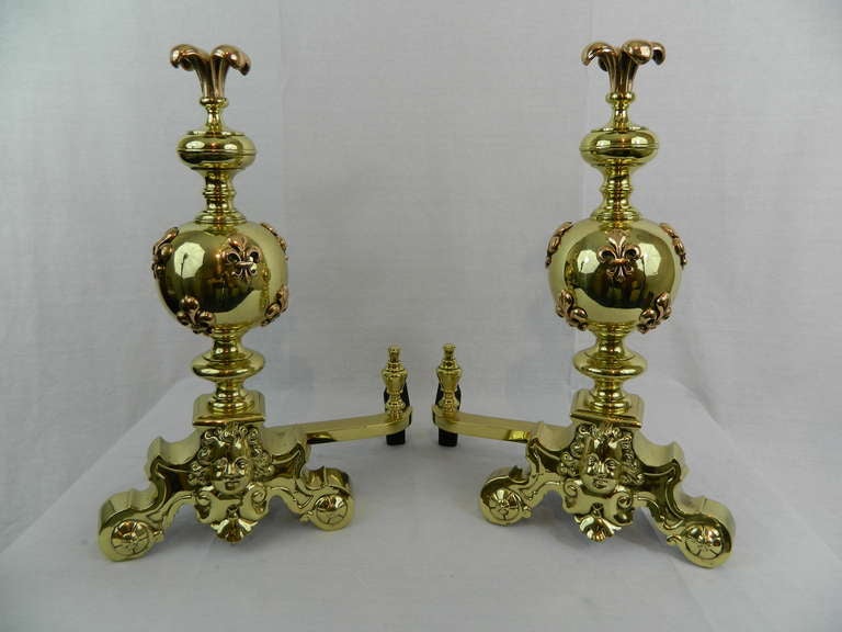 19th century pair of chenets or andirons with a fleur-de-lys motif finials and cherub faces on bases.