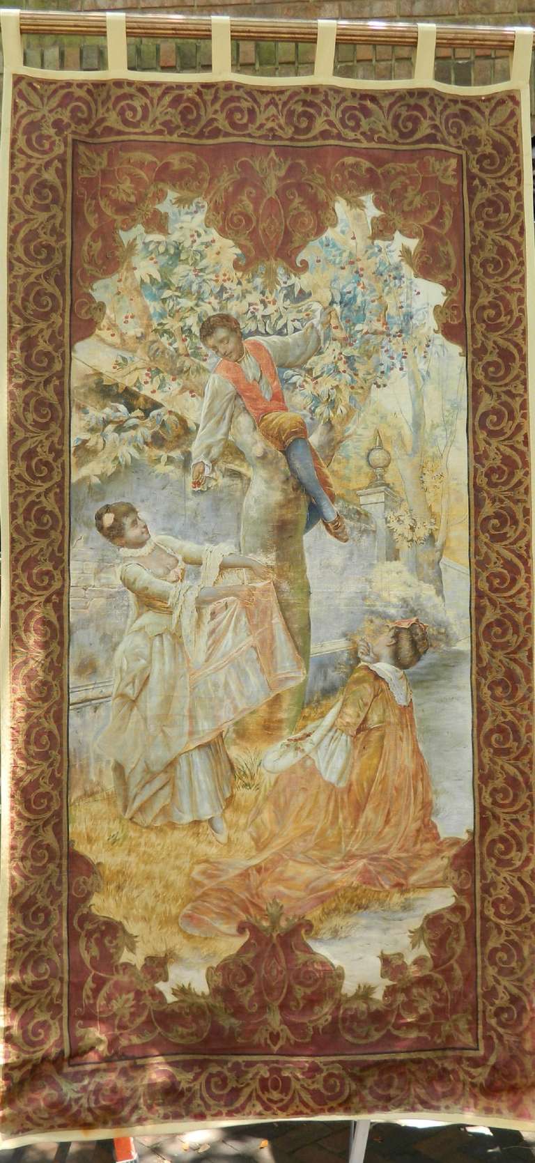 französischer Wandteppich des 19. Jahrhunderts mit einer Szene, die einen Jungen und zwei Mädchen beim Kirschenpflücken zeigt.  Der Rand und die Handhaken wurden später hinzugefügt
