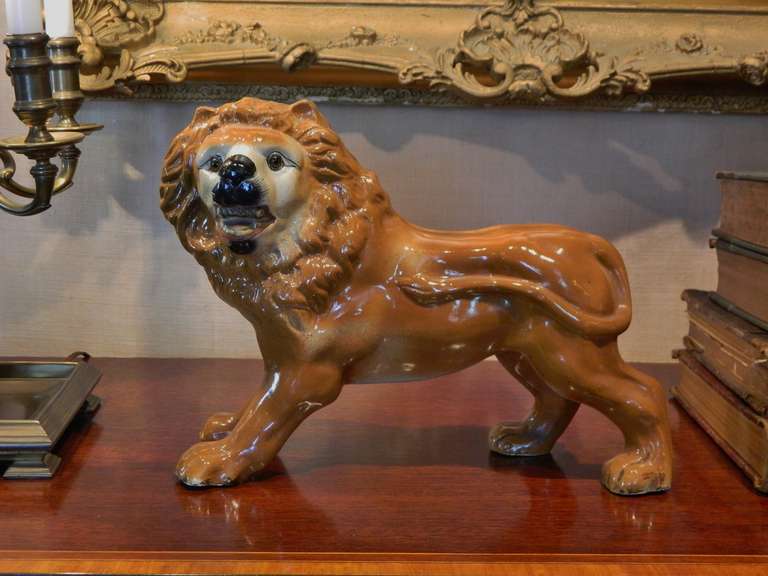 Pair of late 19th century Staffordshire figures, depicting opposing lions with glass eyes.