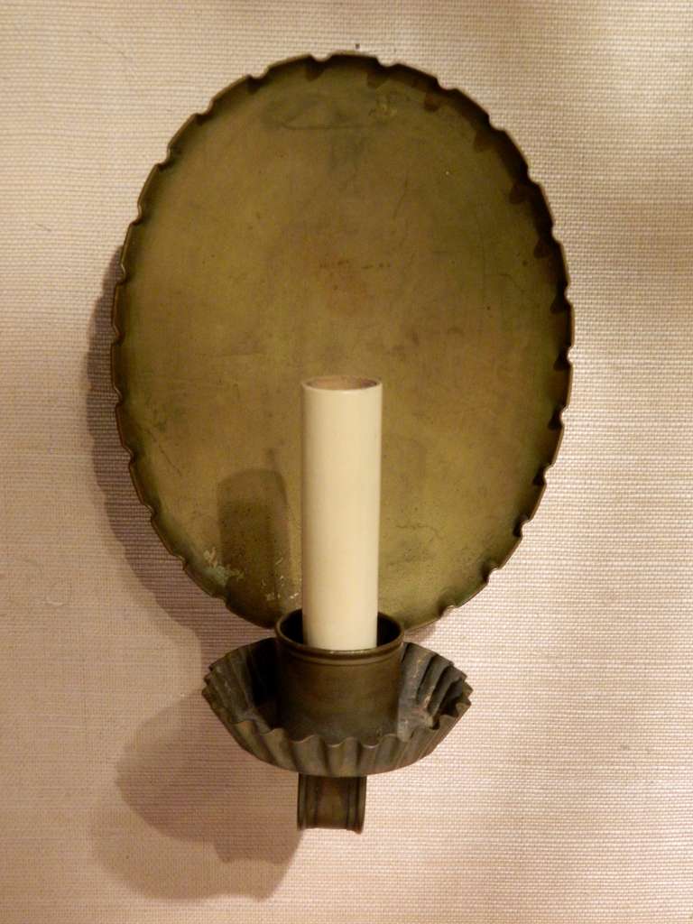 Circa 1920's Pair of Single Candelabra Light Brass Colonial Revival Style Sconces with a Ruffled Edge.  Nice and clean updated version of a primitive candle sconce