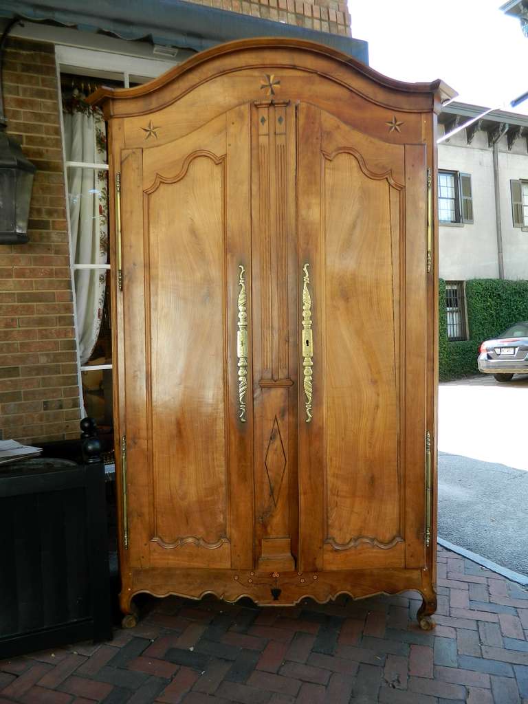 18th century Louis XV fruitwood armoire with stars and flower inlay.