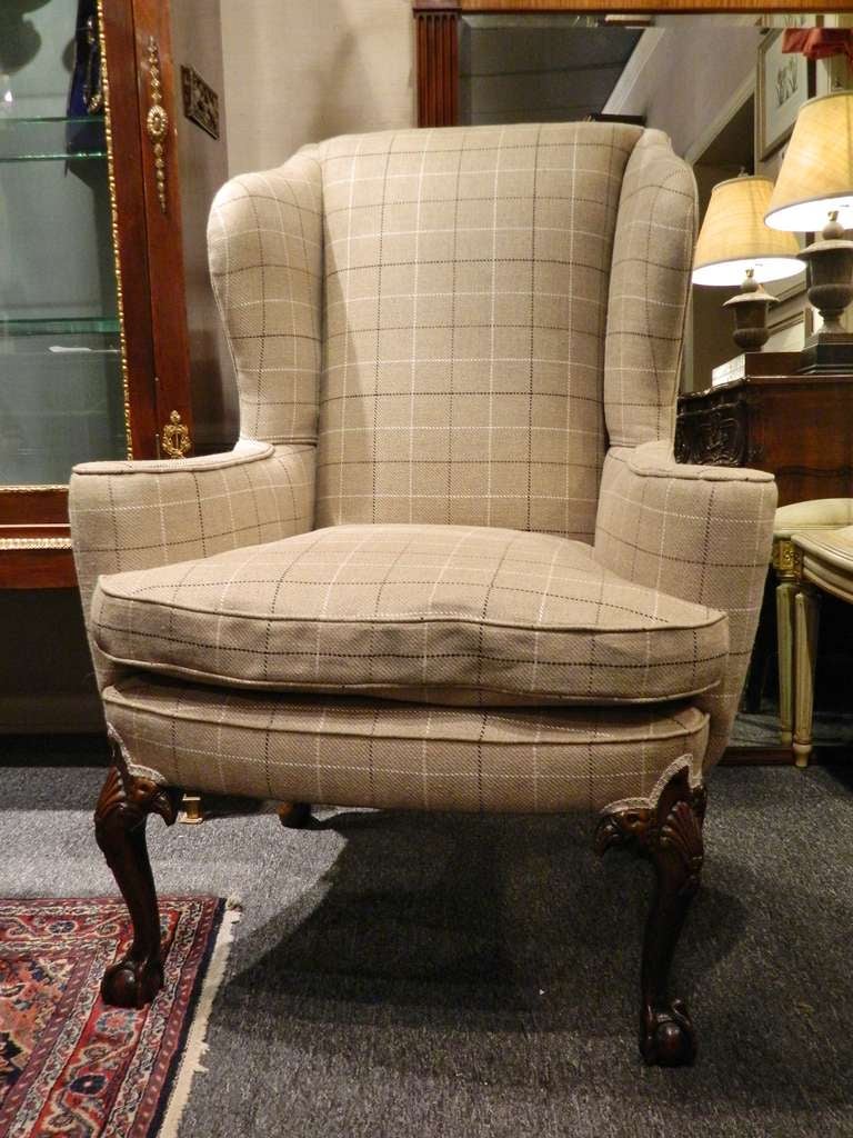 Late 19th century Chippendale-style centennial mahogany wing back chair upholstered in wool tweed. The padded rectangular back joined by shaped sides and out scrolled arms to the cushioned seat, raised on cabriole legs headed by shell and double