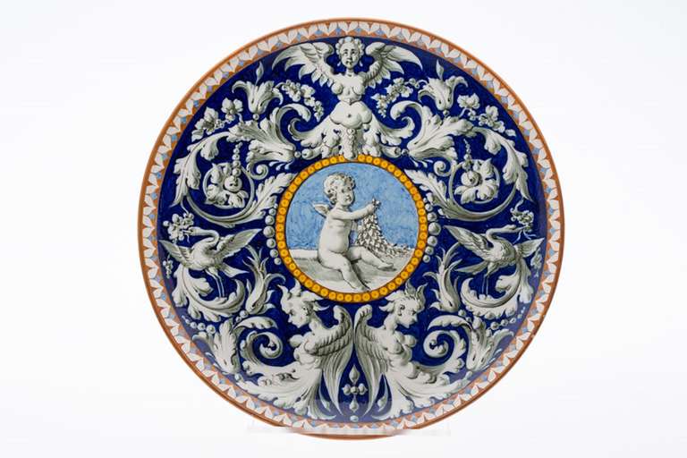19th century Richard Ginori faience charger, decorated with putti surrounded by scrolling decoration, birds and caryatids.