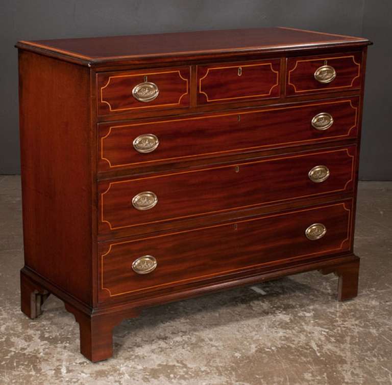 Circa 1800s Inlaid Sheraton mahogany chest with satinwood cross-banded top, three small drawers over three full graduated drawers and bracket feet