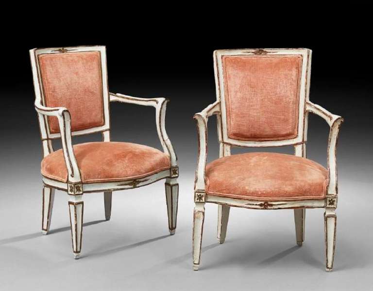 19th century pair of Italian neoclassical polychrome fauteuils or armchairs, each with a tapering rectangular padded back, joined by scrolling arms to the padded seat, raised on paneled tapering square legs.