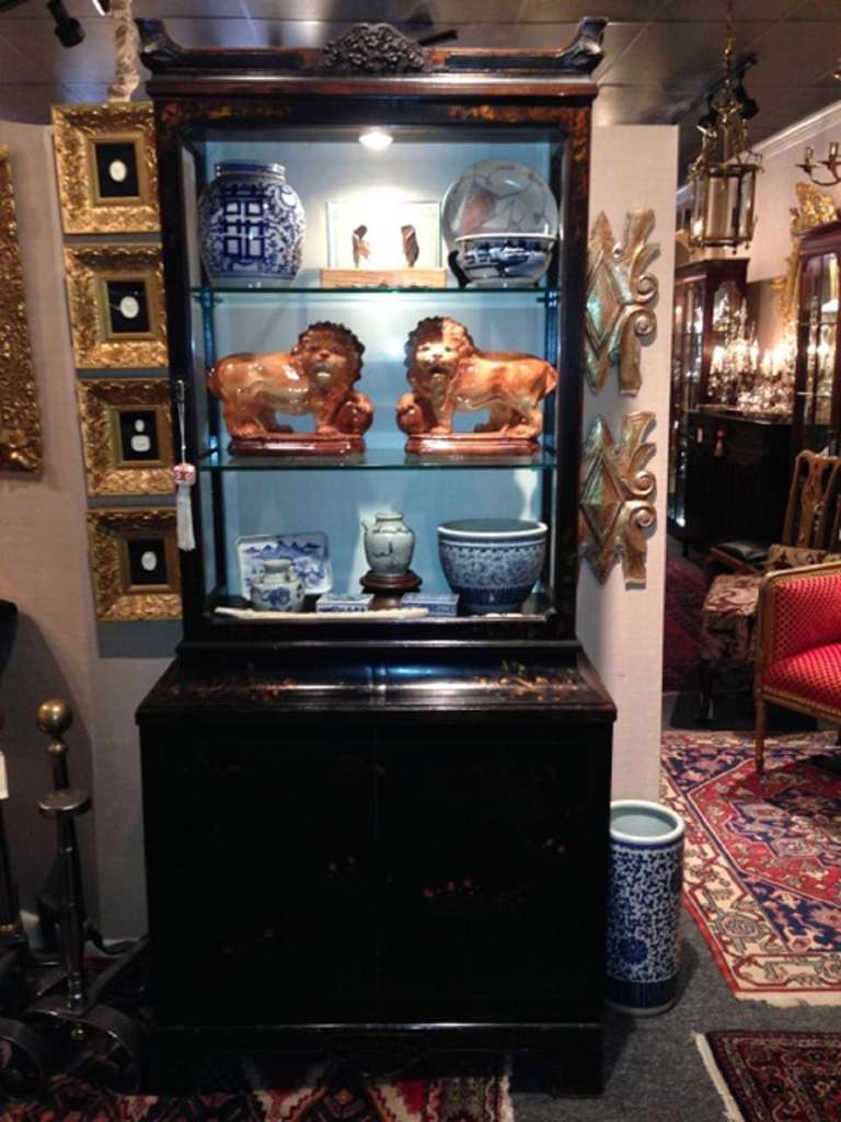 19th century chinoiserie display cabinet with glass shelves, two hidden drawers, and opening to two bottom doors.