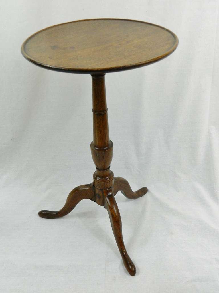 Late 18th century George III oak candle stand. The circular top with raised ring above a ring-turned and reeded shaft above three cabriole legs ending in pad feet.