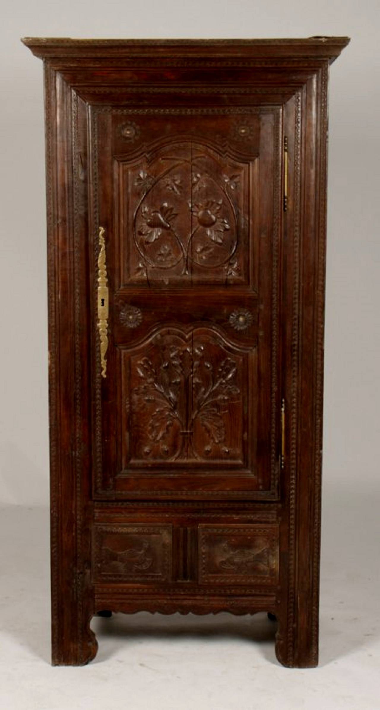 A French Oak Bonnetiere with incised border at cornice over one carved door with brass escutcheon, Early 19th Century