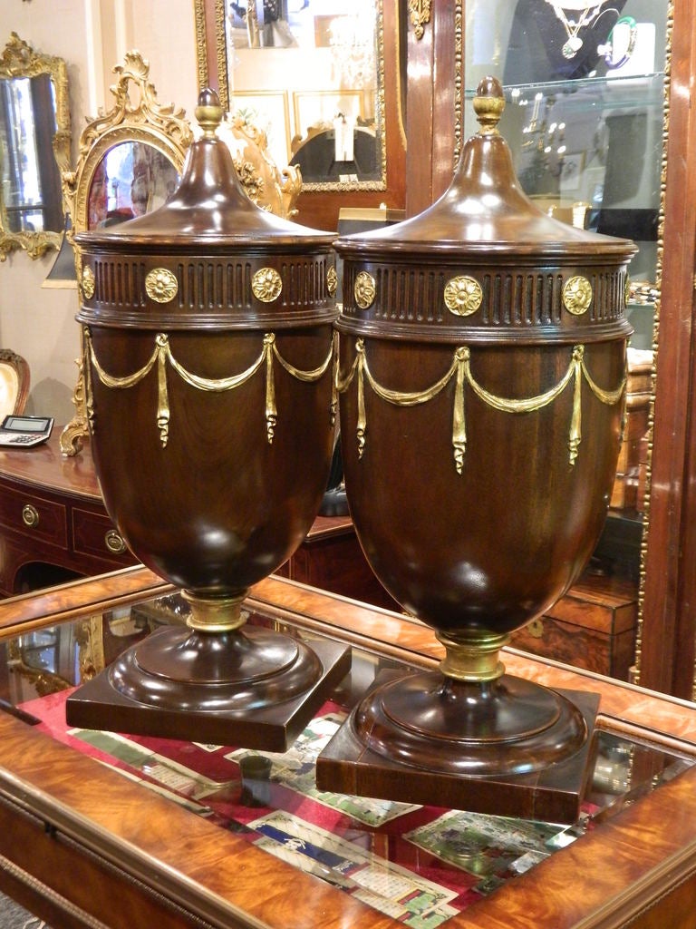 Pair of Mahogany Knife or Cutlery Urn Forms Encircled with Gilded Fluted and Rosette Band Draping Swags Beneath an Upswept Cover with Acorn Finial on a Square Foot, Early 20th Century.  Green Felt Interior.  Bases are 9