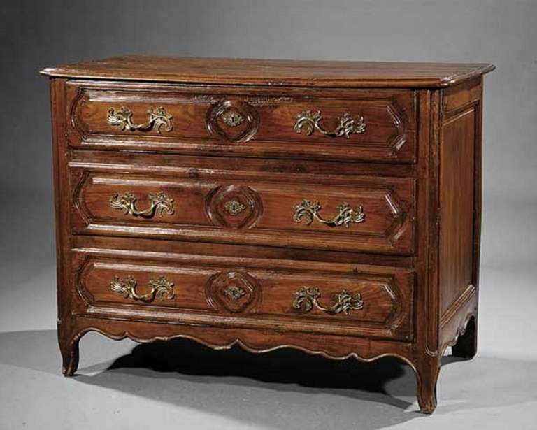Mid 18th Century French provincial carved walnut commode or chest of drawers, molded top, three drawers, canted stiles, paneled sides, and shaped feet.