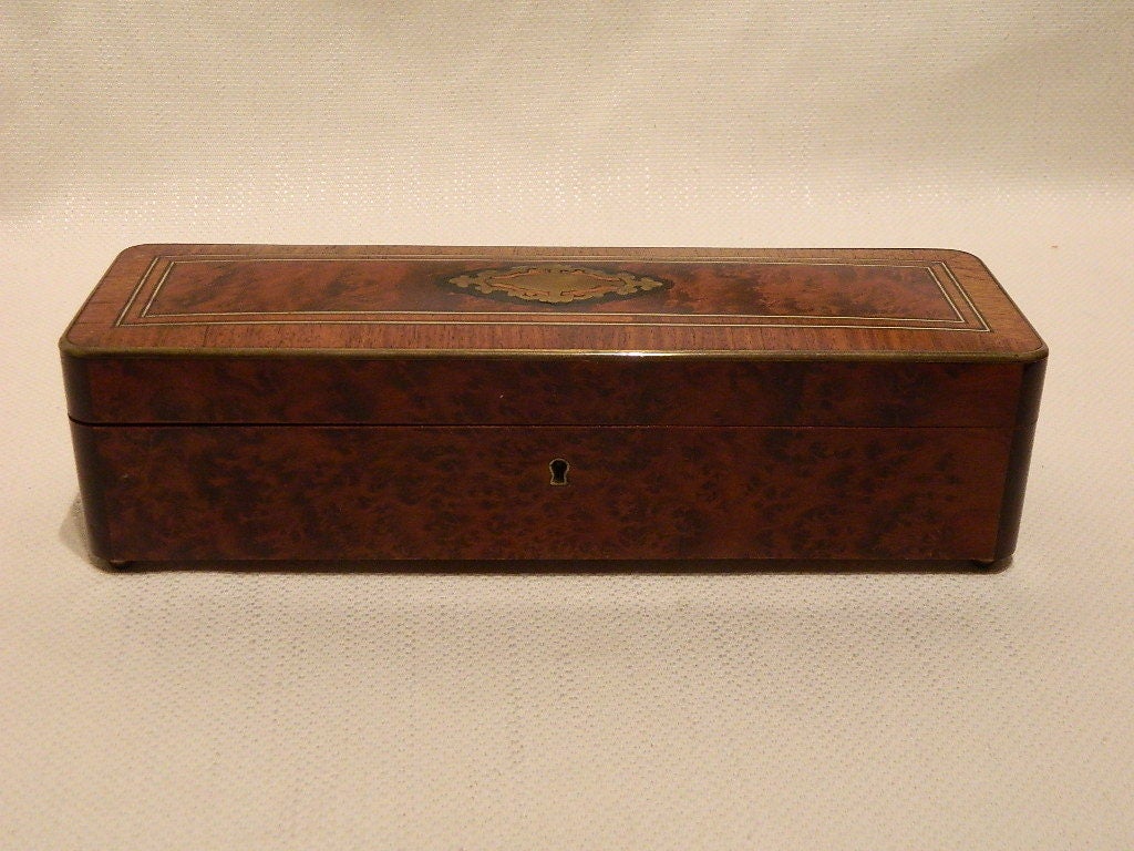 Amboyna Burl Wood and Brass-Inlaid Glove Box with a brass plate and string-inlaid borders with brass framing along the lid edge, padded and tufted interior and retaining locking key