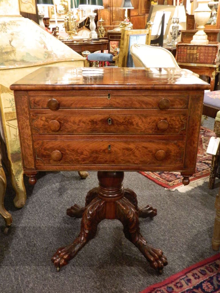 19th century mahogany classical carved work table on a single baluster and ending in carved claw feet on casters.