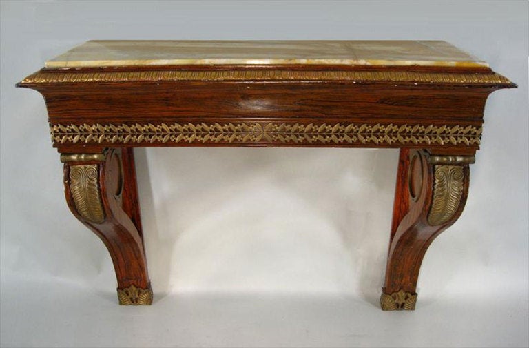 Mesa consola neoclásica europea con tablero de mármol veteado de palisandro montado en ormolina, patas con roleos, tablero de mármol melocotón desmontable, borde superior moldeado en dorado de huevo y dardo, monturas de ormolina con hojas de agua y