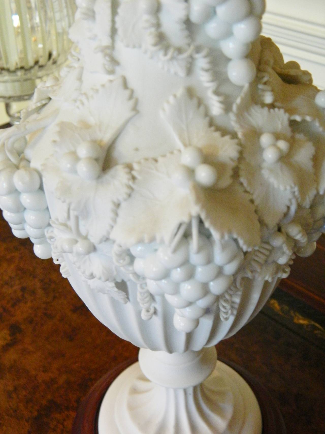 Pair of White Bisque Porcelain Urns with Handles and Fruit Relief