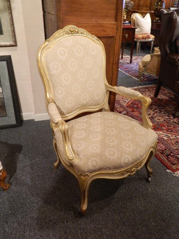 Pair of painted and gilt Napoleon III armchairs. Floral motif carvings. Legs ending on casters. 19th century.