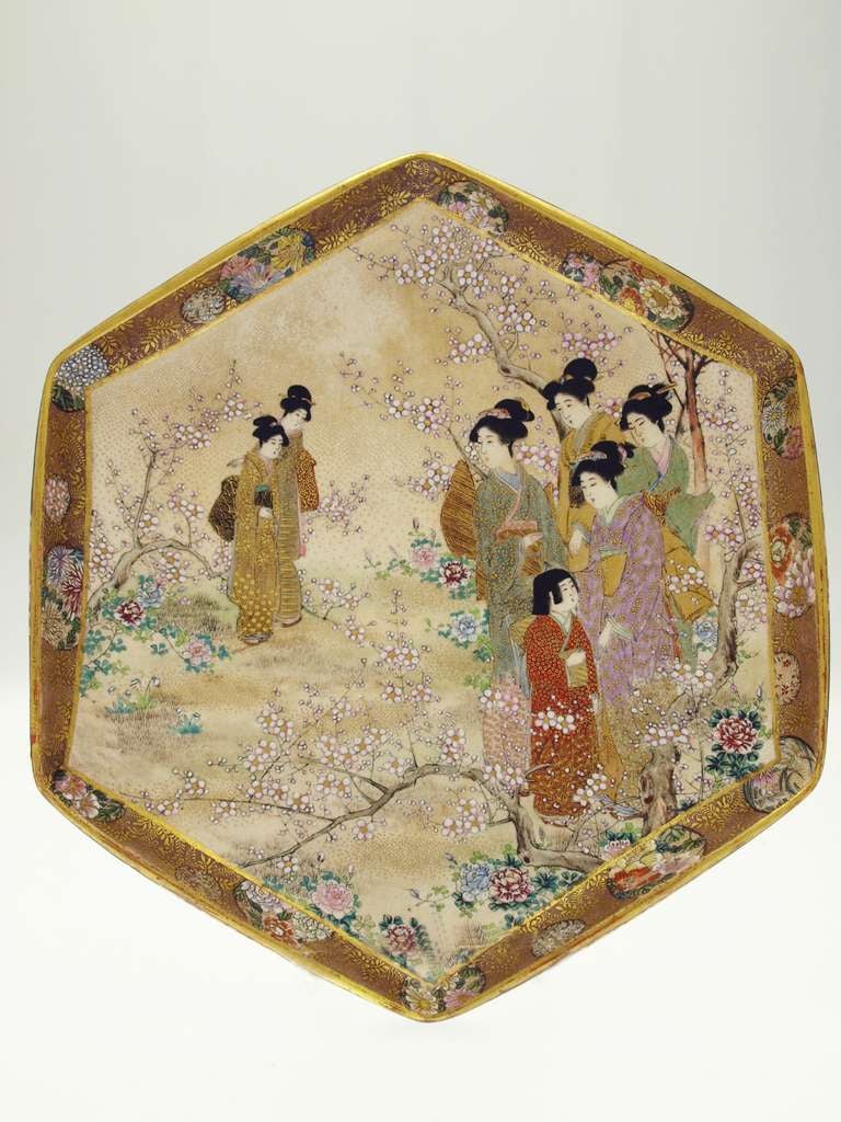 A Japanese Satsuma earthenware dish, Meiji period, the hexagonal body painted and gilt with of figures of ladies and child among flowers, reserved against a simulated brocade and flower ground, gilt signature to base: Yasuda?

Size: diameter: 25