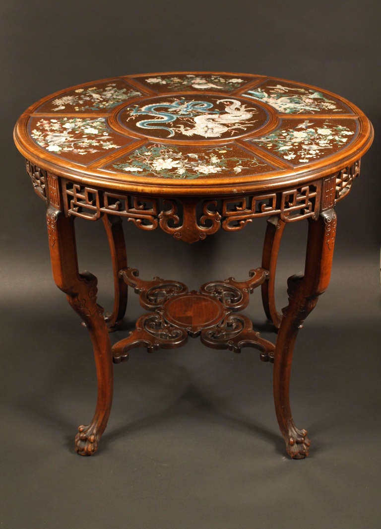 This exceptional carved walnut table is a fine example of Japonism in France at the end of the 19th century. The top is decorated with Japanese cloisonne plaques with a goldstone ground (aventurine). The six fan shape plaques are decorated with