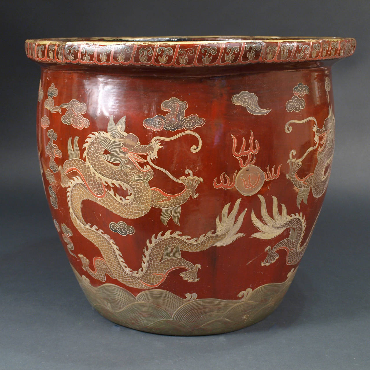 A large Chinese lacquer jardiniere decorated with dragons among the clouds looking for the sacred pearl.
The upper rim is decorated with bats and longevity peaches,
China, end of the 19th century.
