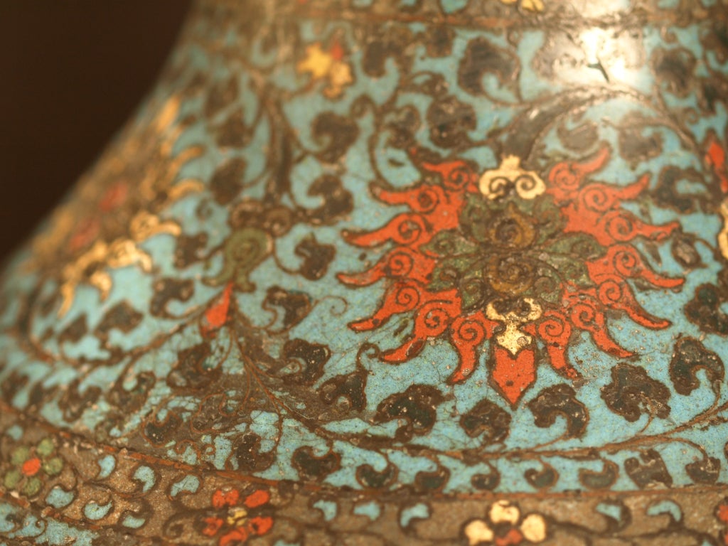 This large Chinese cloisonne enamel vase has a  globular body with waisted neck and tall spreading foot. The Chinese name of this shape is HU. The decorative motifs are divided into horizontal registers of decorative band with classic lotus scrolls.