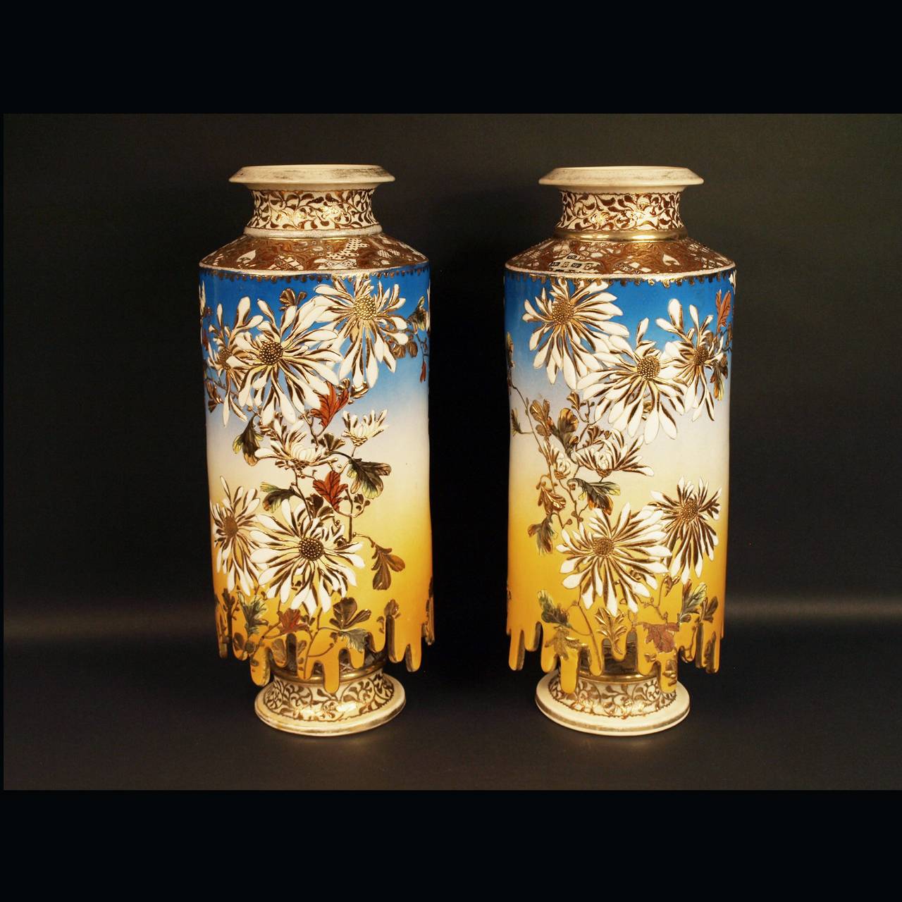 Japan, Satsuma, Pair of vases, end of the Meiji period. 

This pair of cylindrical vases have a very unusual shape as well a quite unusual mirror decoration of flowers painted on a orange yellow and bright blue ground.
Hauteur: 45, diameter: