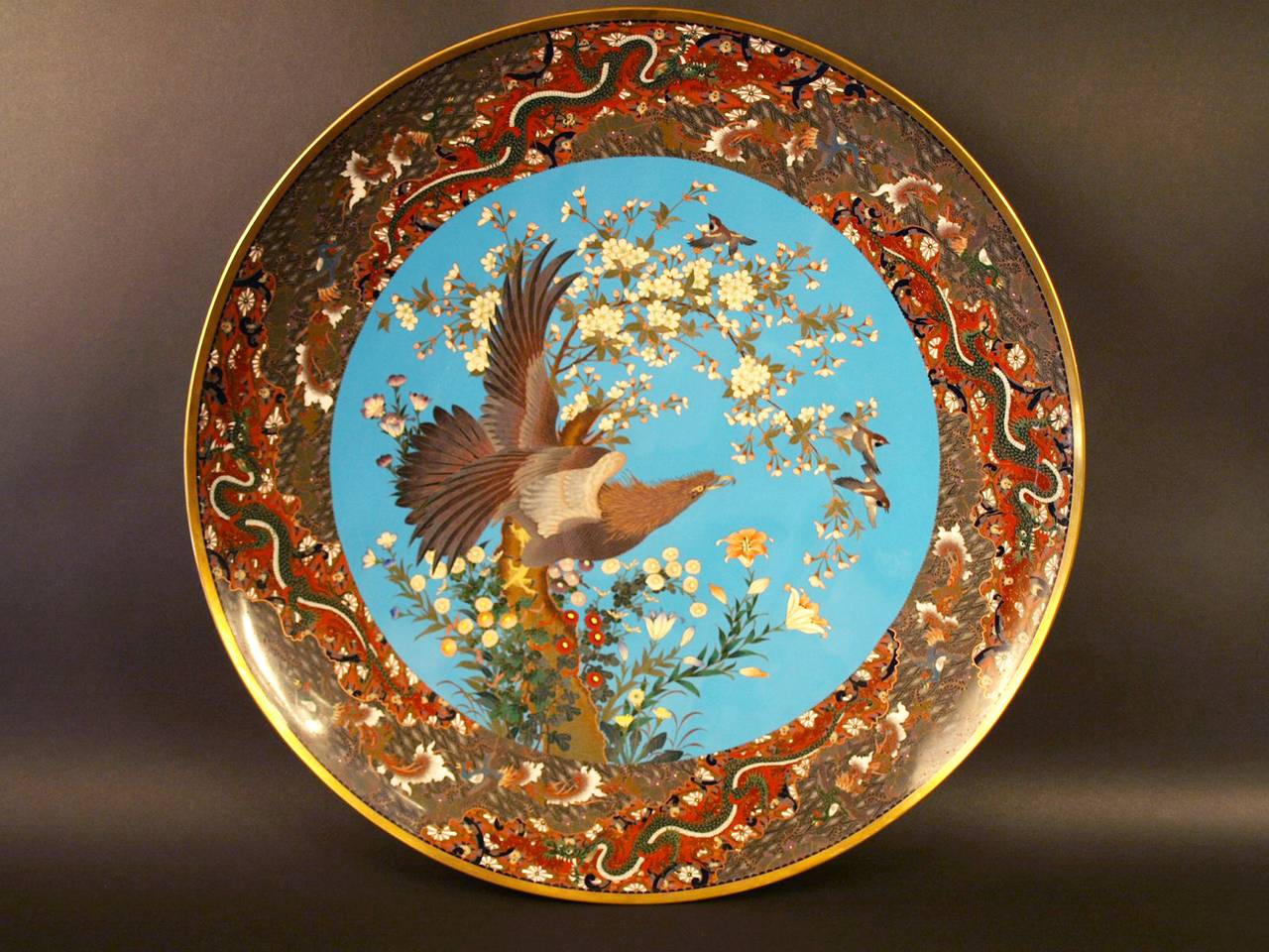 Large Japanese Meiji Cloisonné charger.  This important charger is decorated with cloisonné polychrome enamels on a  turquoise blue background. It represents an eagle on a blossoming cherry tree. The border  is decorated with alternating zones