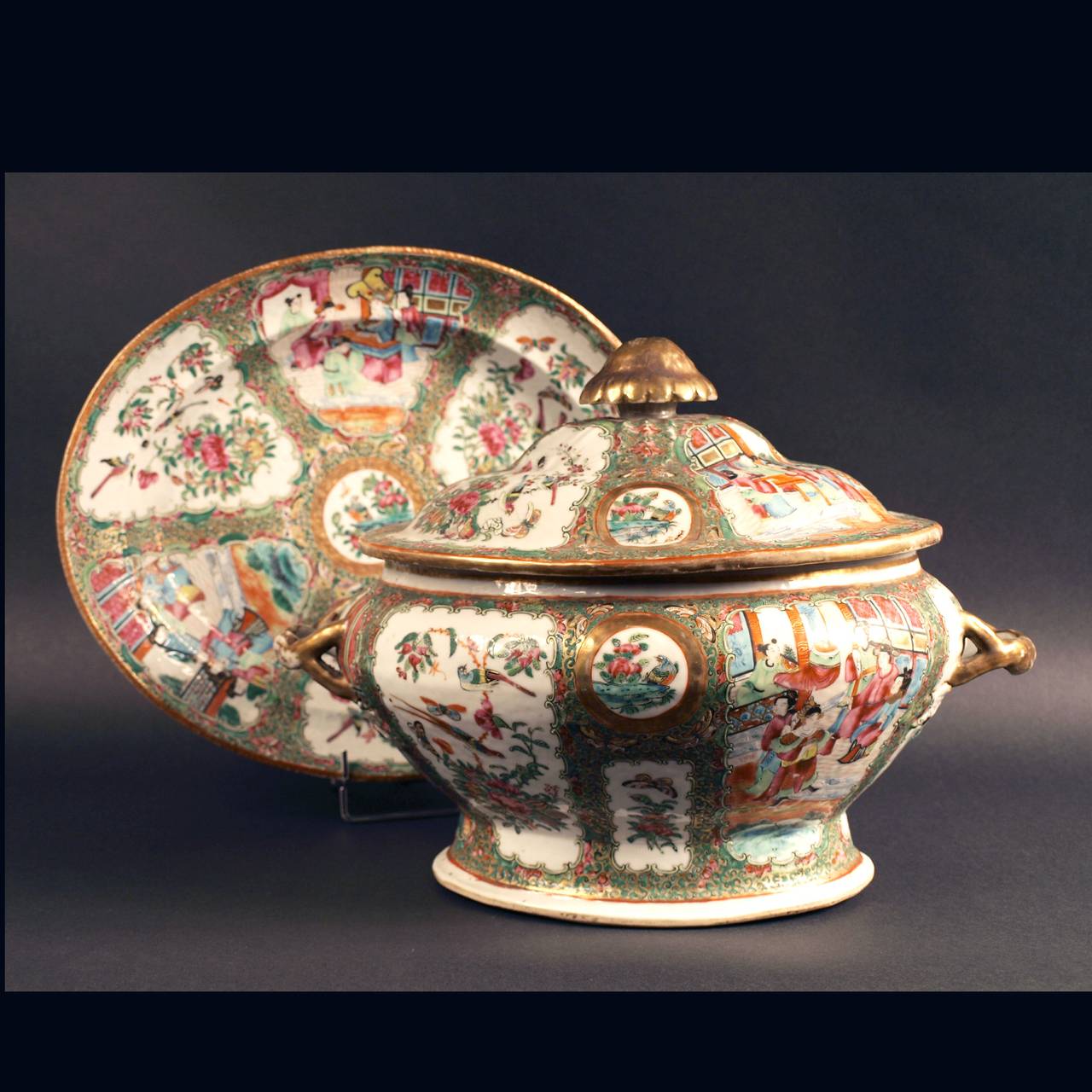 A Chinese export Canton rose Medallion  soup tureen, cover and stand, 19th century, decorated with figures in a landscape or birds and blossom within cartouches.
The tureen: 37 cm x 25cm x 25,5.
The stand: 36cm x 29,5 x 6 cm.
China for export