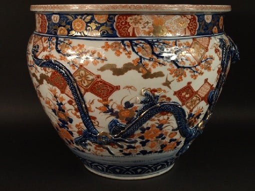 Large Imari fish bowl decorated in undercover cobalt blue, iron red and gold with a basket, sprays of flowers and  two large high relief dragons around.
Signed.
Imari, Arita, Meiji period, end of the 19th century