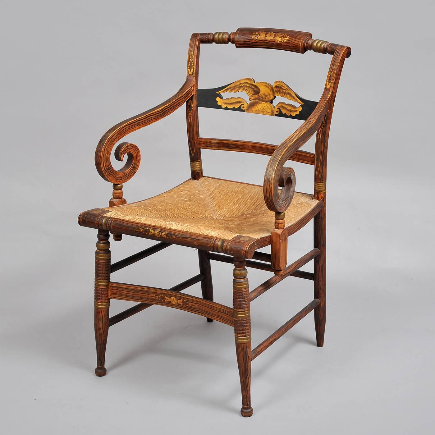 Rush seated armchair, flanked by scrolled arms with carved pierced splat depicting an eagle perched on a globe in gilt stencil. The chair boasts turned tapered legs, fluting with contrasting veneers. Typical of the Sheraton style with swags,