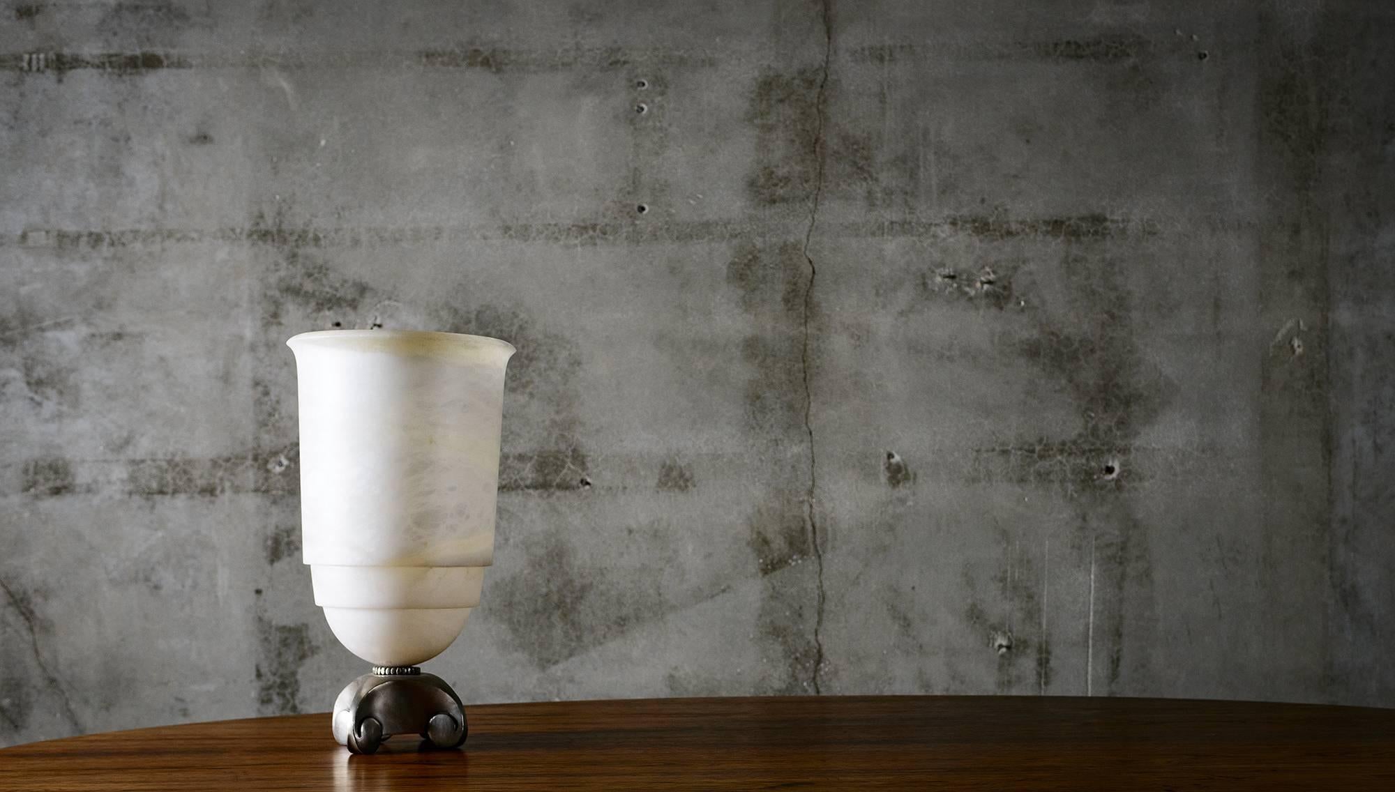 Evoking the heritage of French master craftsmen Emile-Jacques Ruhlmann, this lamp vase made from alabaster with silvered bronze base is notable for its classical simplicity crafted with the finest materials, harmonious proportions, architectural