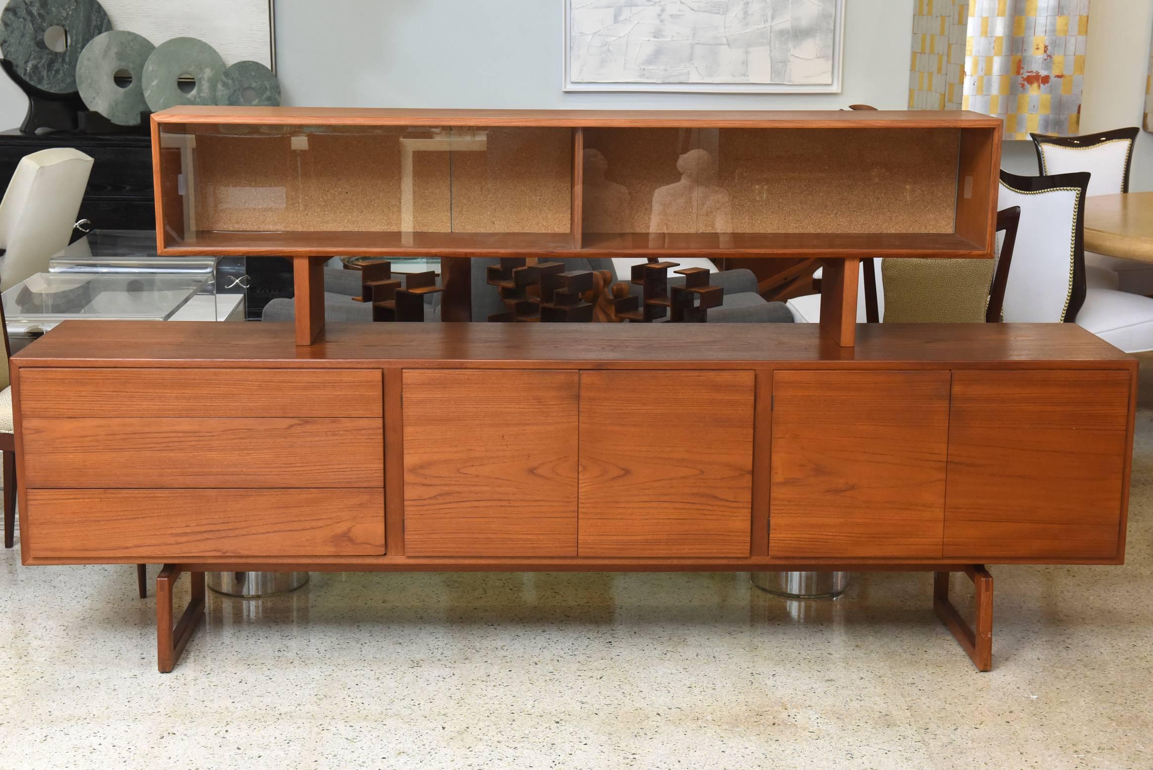This Danish modern teak sideboard with superstructure by Bodil Kjaer was manufactured for E. Pedersen and Sons, circa 1950s. The piece comes with three compartments on a raised legs. The superstructure is elevated with two compartments for storage.
