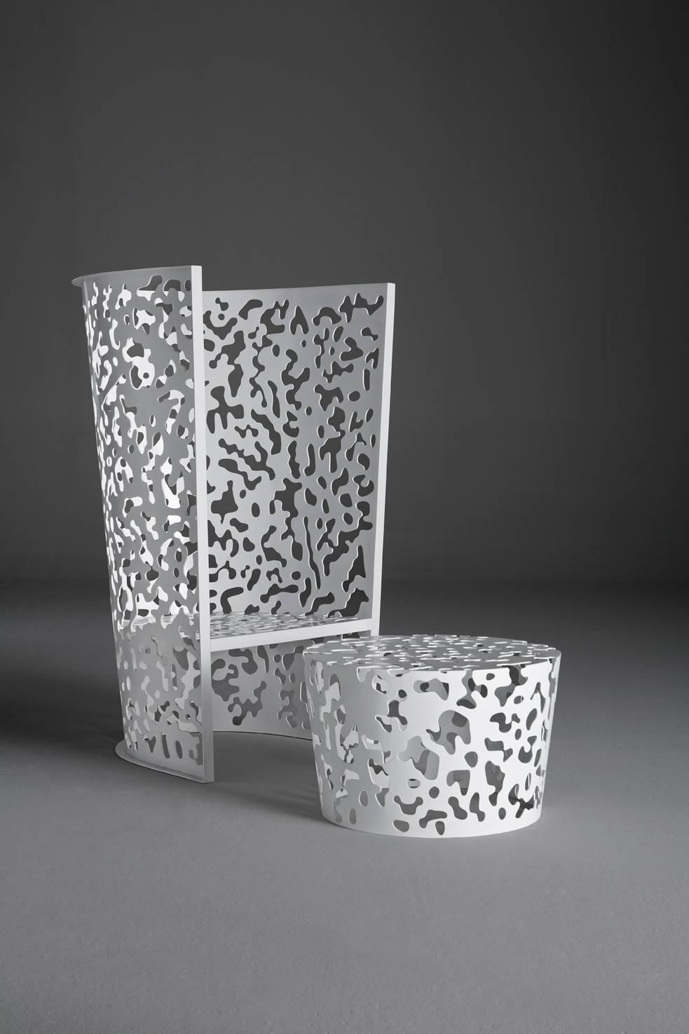 Camouflage ist eine Outdoor-Kollektion, die einen hohen und einen niedrigen Sessel, einen Tisch und einen kleinen Tisch umfasst, die alle aus Aluminium gefertigt sind. Bei diesen skulpturalen Elementen umrahmt die geometrische Gestaltung der
