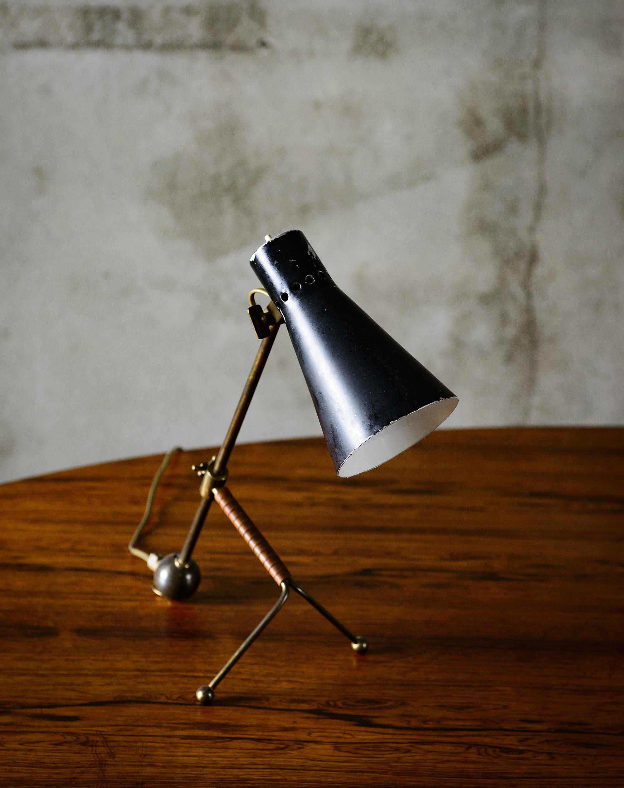An icon of Scandinavian design the Tapio Wirkkala table lamp boasts tubular brass with enameled aluminum. Produced by Idman, Model K11-16, Finland, 1958. The lamp is in good condition with minor scratches on shade. Vintage.