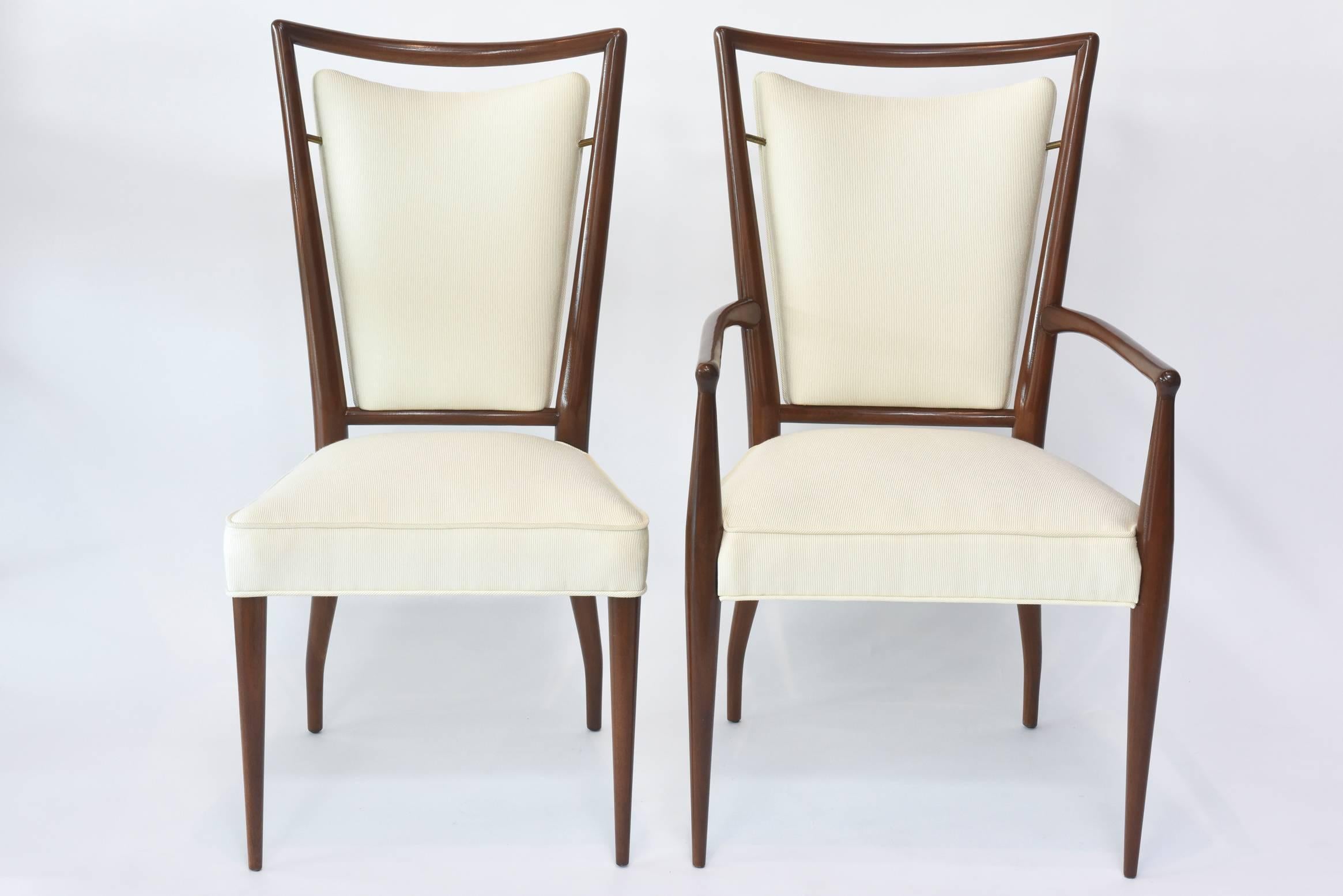 From designer J. Stuart Clingman, this set of 14 American modern walnut and brass dining chairs made in the1950s comes with sleek tapered spindle legs with upholstered backrest encased in a spindled frame gently resting on delicate brass hinges.