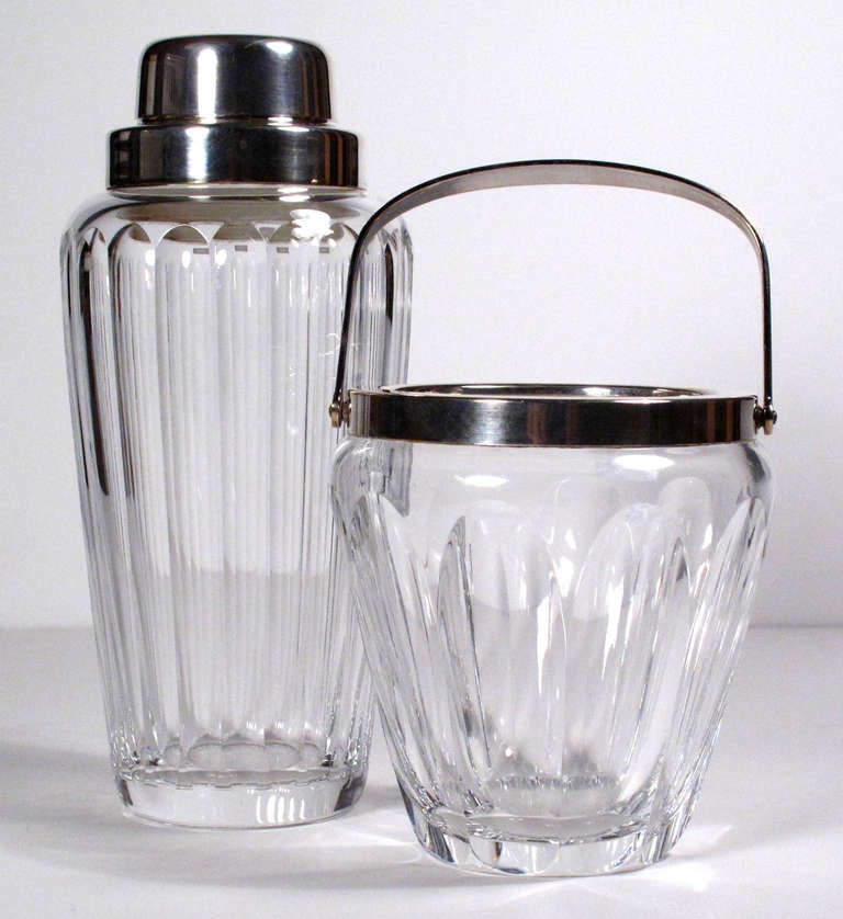 A matching barware set consisting of a crystal ice bucket and cocktail shaker with silver-plated accents. Shaker has maker's sticker. Sold individually.

Shaker: $300 8