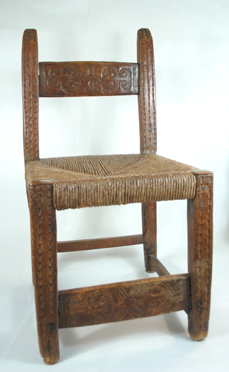 Low Chair probably made in the  Michoacan area.  The carvings and manufacture of the chair as well as its wear indicate late Spanish Colonial. Utilitarian in nature judged by its primitive folk design. However, the chair very sturdy, literally made
