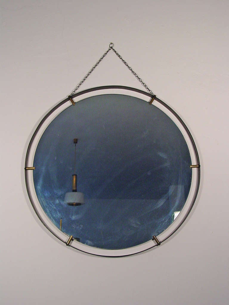 A wonderful Italian wall mirror in black lacquered metal and brass