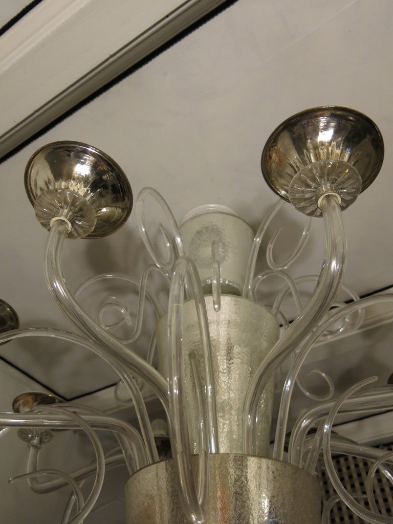 Beautiful chandelier in Murano glass. Two large cups mirrored glass with tiny bubbles. Arms of the beautiful transparent glass with eight lights and many curly transparent both above and below. Very good light reflections when it is illuminated.