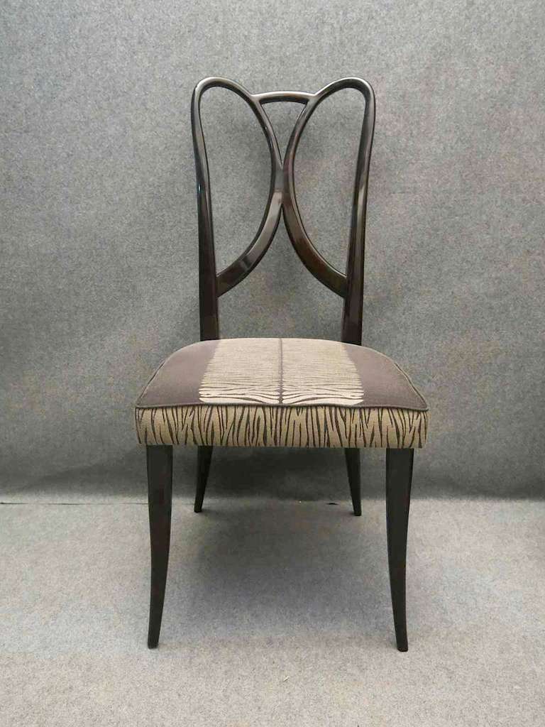 Four chairs attributed to Guglielmo Ulrich, all in beechwood polished in black mahogany lacquer. Its curved wooden back, wide and pleasant. Its equally wide and comfortable seat. Four slightly saber legs, two are the continuation of the back, as you