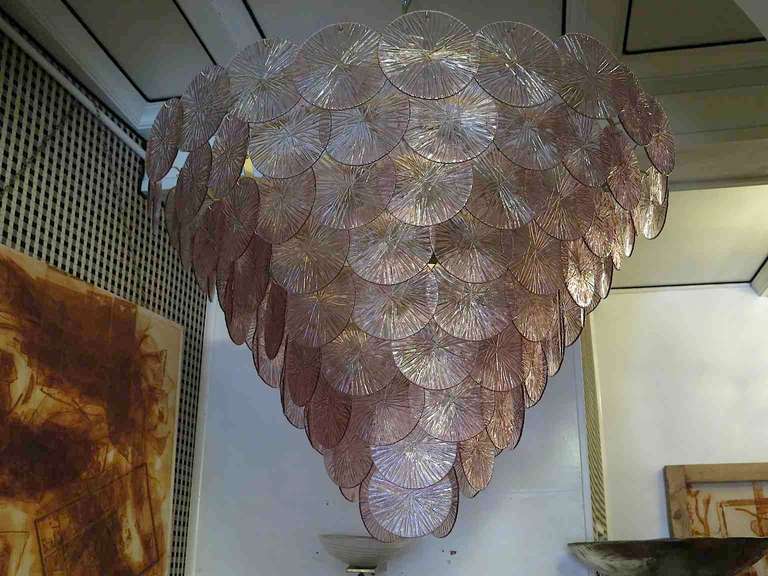 1970, Murano chandelier, with large glass medallions, amethyst color. Composed of an iron structure, hung around with large amethyst glass medallions in Murano glass. The chandelier has an inverted pyramid shape with a round base. Of great effect