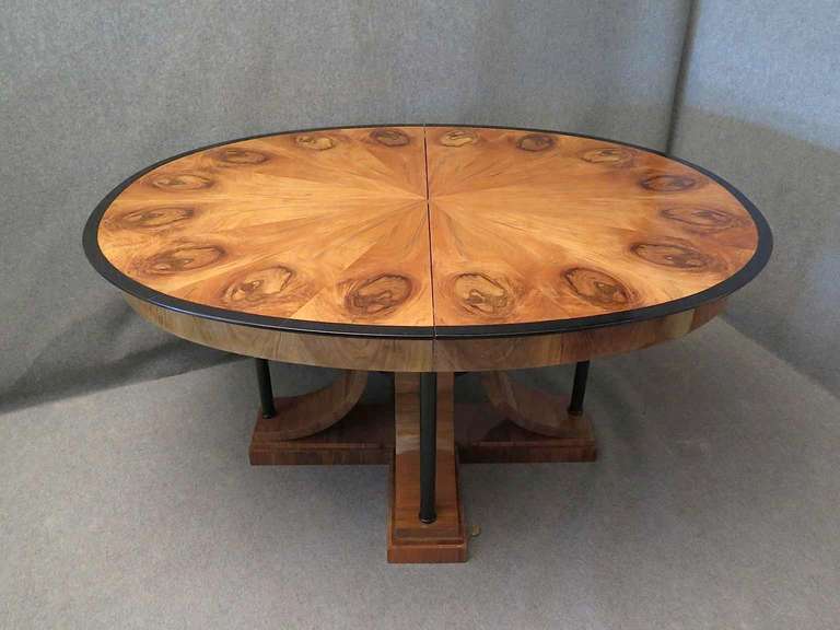 An important Biedermeier table, with a very big oval top, and a very particular leg. The table top is veneered with a beautiful walnut with parts forming the segments of the pie. The central leg is formed by a central massive of walnut and by four