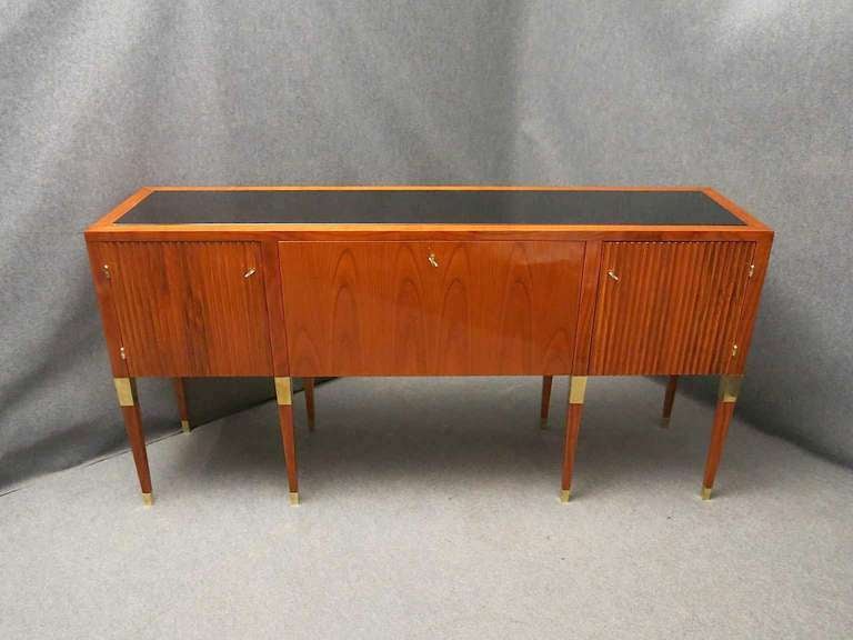 Beautiful art deco sideboard, veneered in cherry wood with brass details, and glass top. very nice movement on the side doors, central door opens to form a plan.
Measuring very beautiful, because it is long and narrow, with no cumbersome measures.