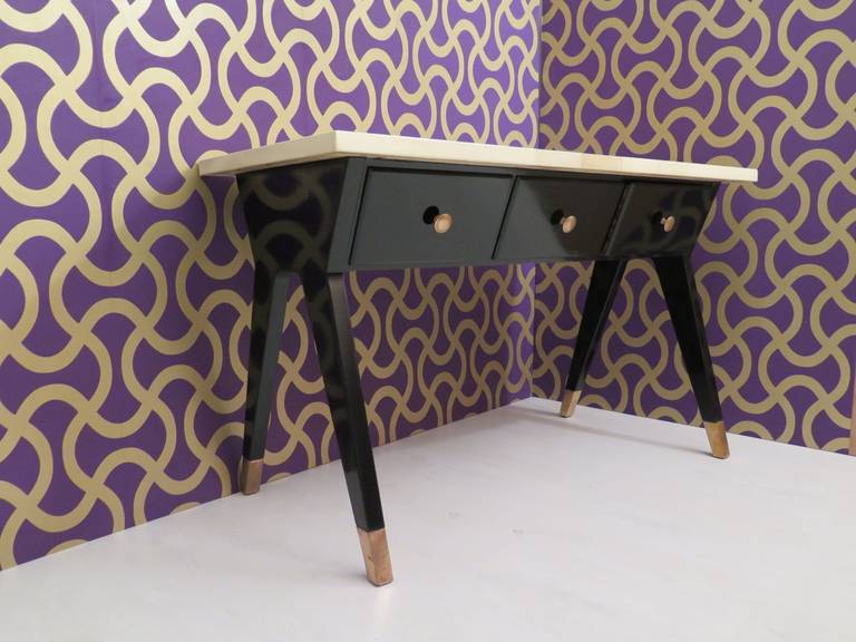 Particular desk art deco,' with the body in black lacquered wood, with three drawers. plan in parchment, with a particular design. Very nice the glasses in brass, to the bottom of the leg.