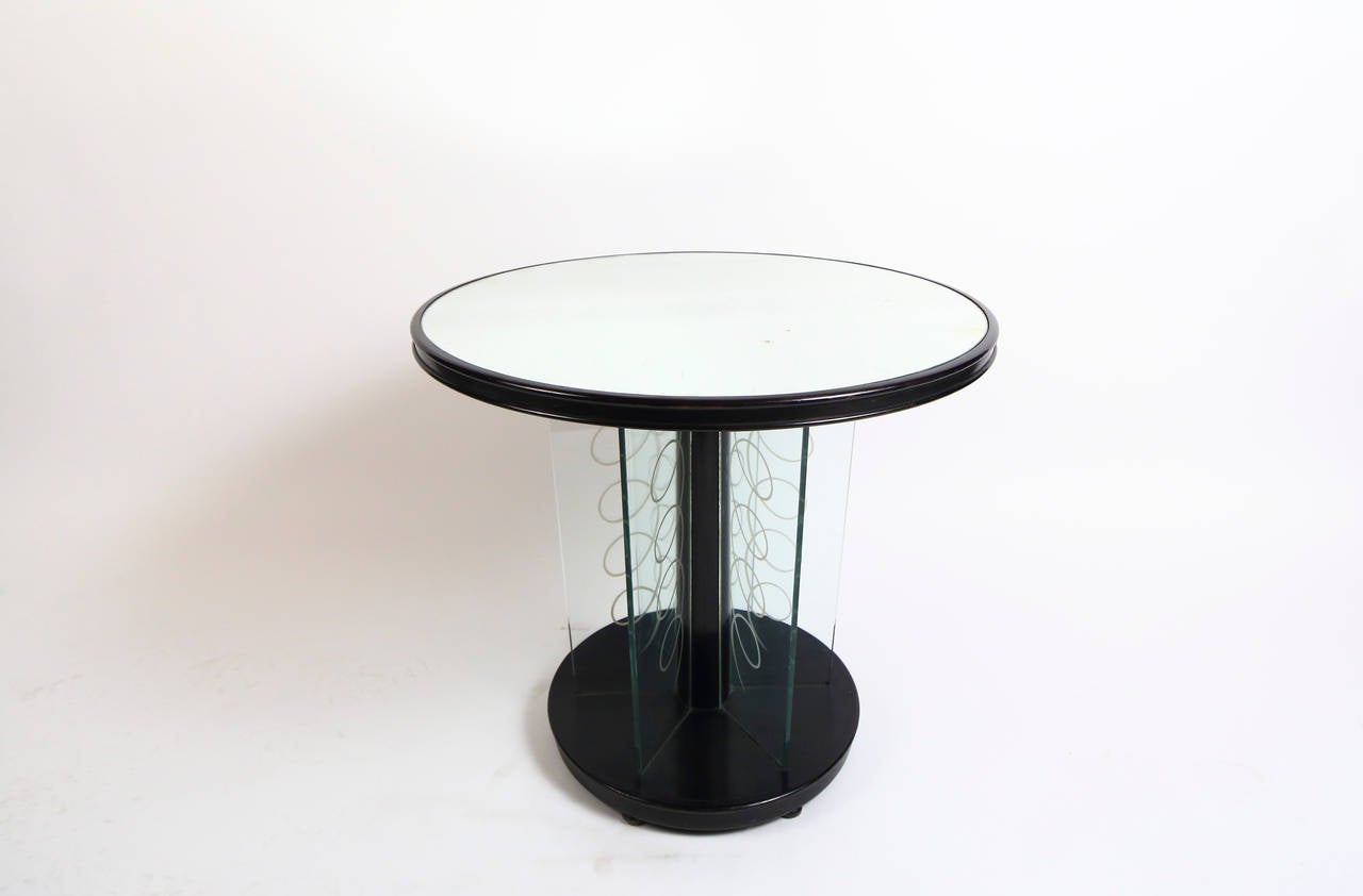 Black laquered wood , four glass plates engraved with spiral pattern inserted between the ground and the base. Blown mirror top Built in the wood top.
Brusotti 1930's.Milano