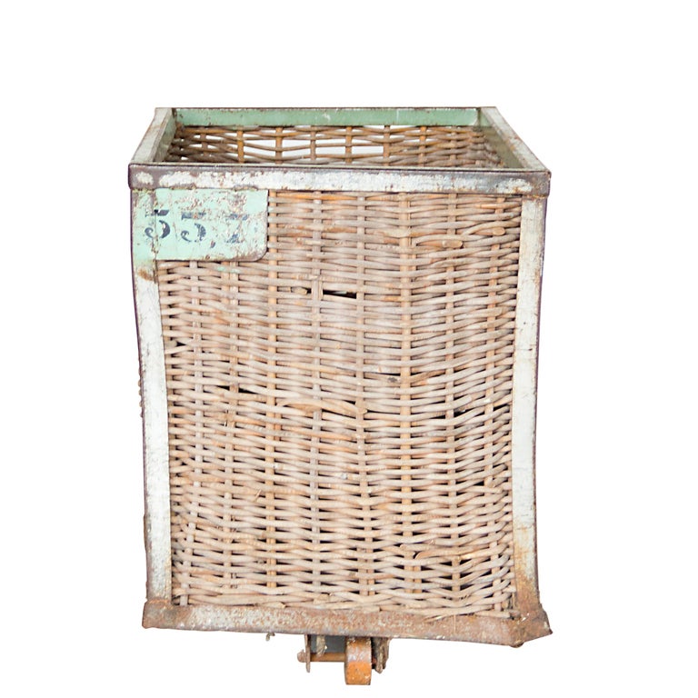 A woven reed laundry basket on metal base.