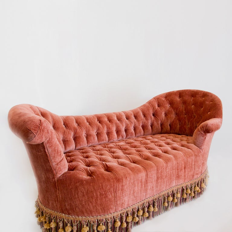 A 19th century loveseat in old pink silky velvet with original tassels.