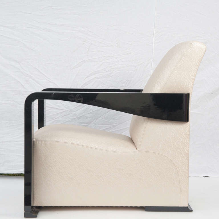 A black wooden lacquered and upholstered club chair by Hugues Chevalier.