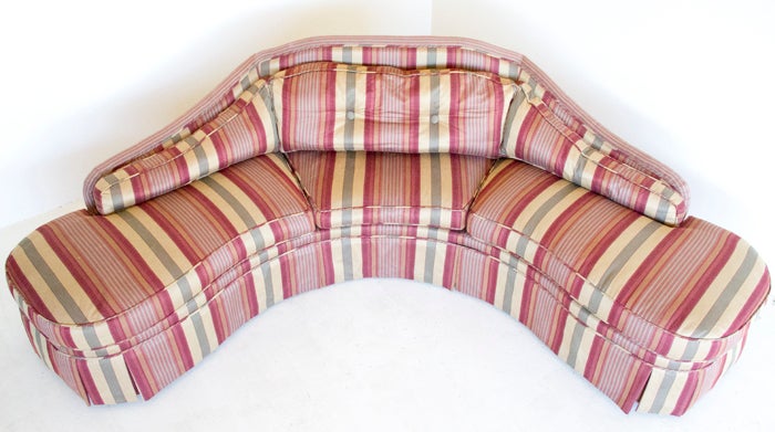 An upholstered sofa in a triangular shape with striped upholstery.